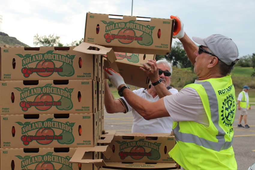 Volunteers for the Rotary Club of Golden load peaches into customers' cars during the "Peaches for a Purpose" pickup Aug. 20 at Golden High School.